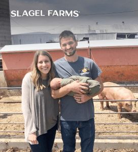 a man and a woman holding a baby in a pen showcasing slagel family farm