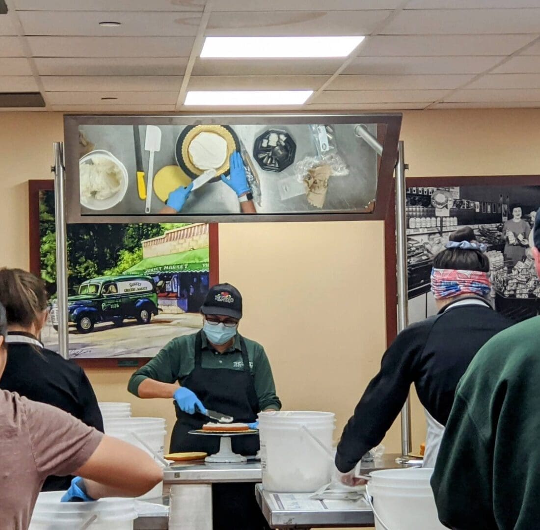 a group of people in a restaurant kitchen preparing food with posters on the wall