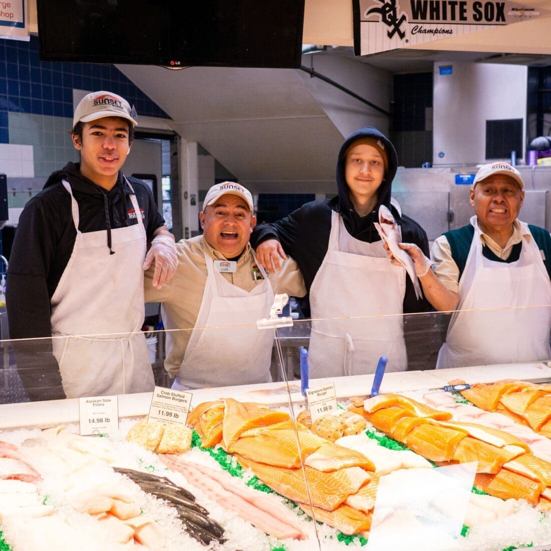 a group of people in aprons behind a seafood counter